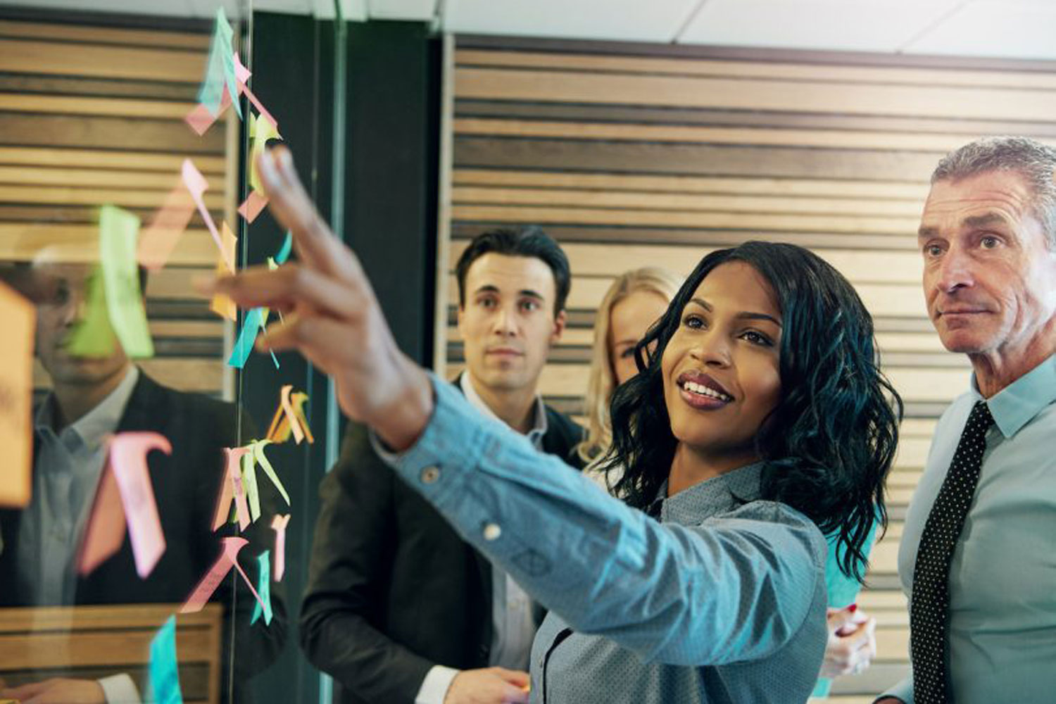 woman pointing at post-it notes woman pointing at post-it notes
