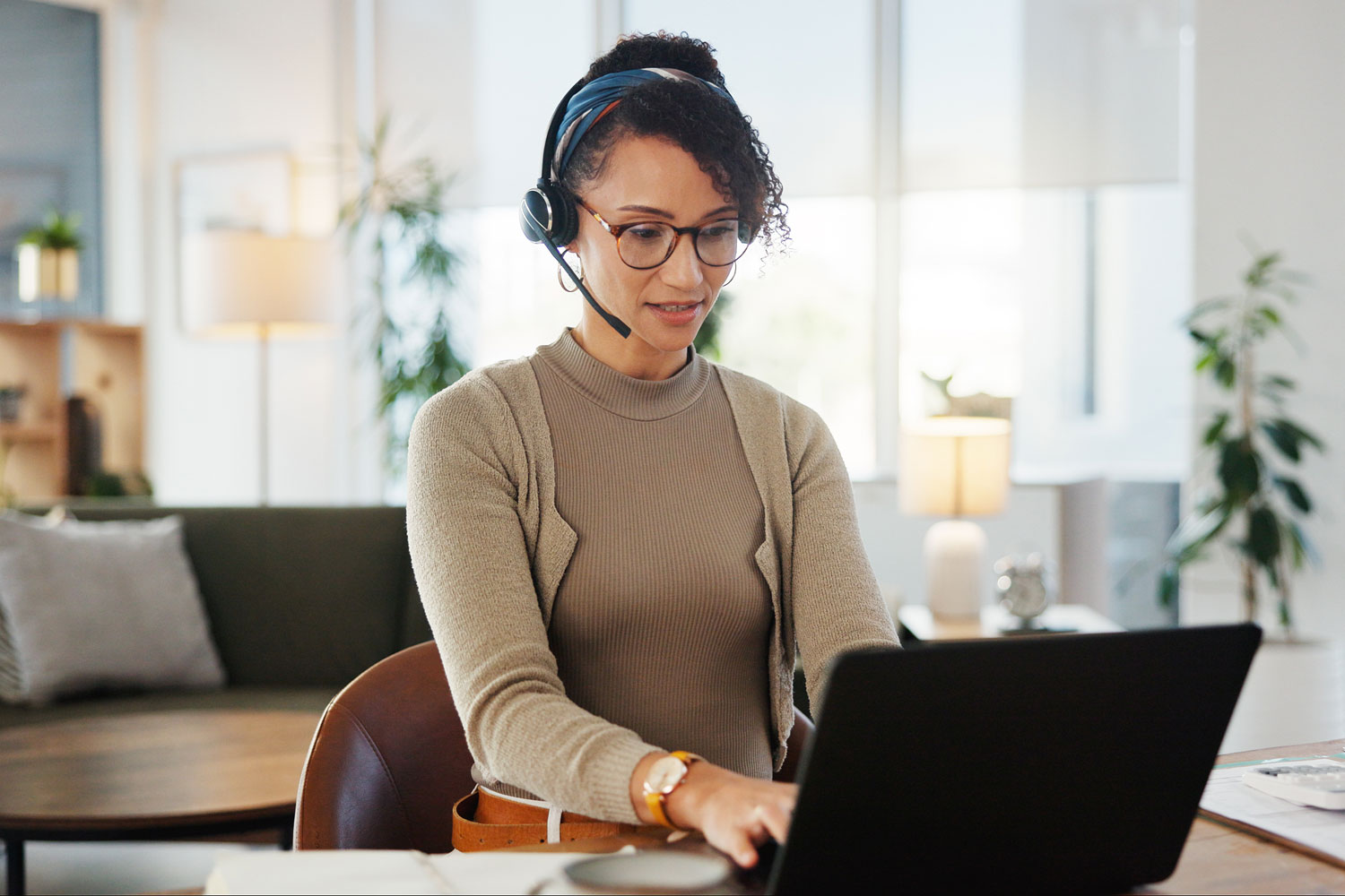 young woman with audio headset at laptop