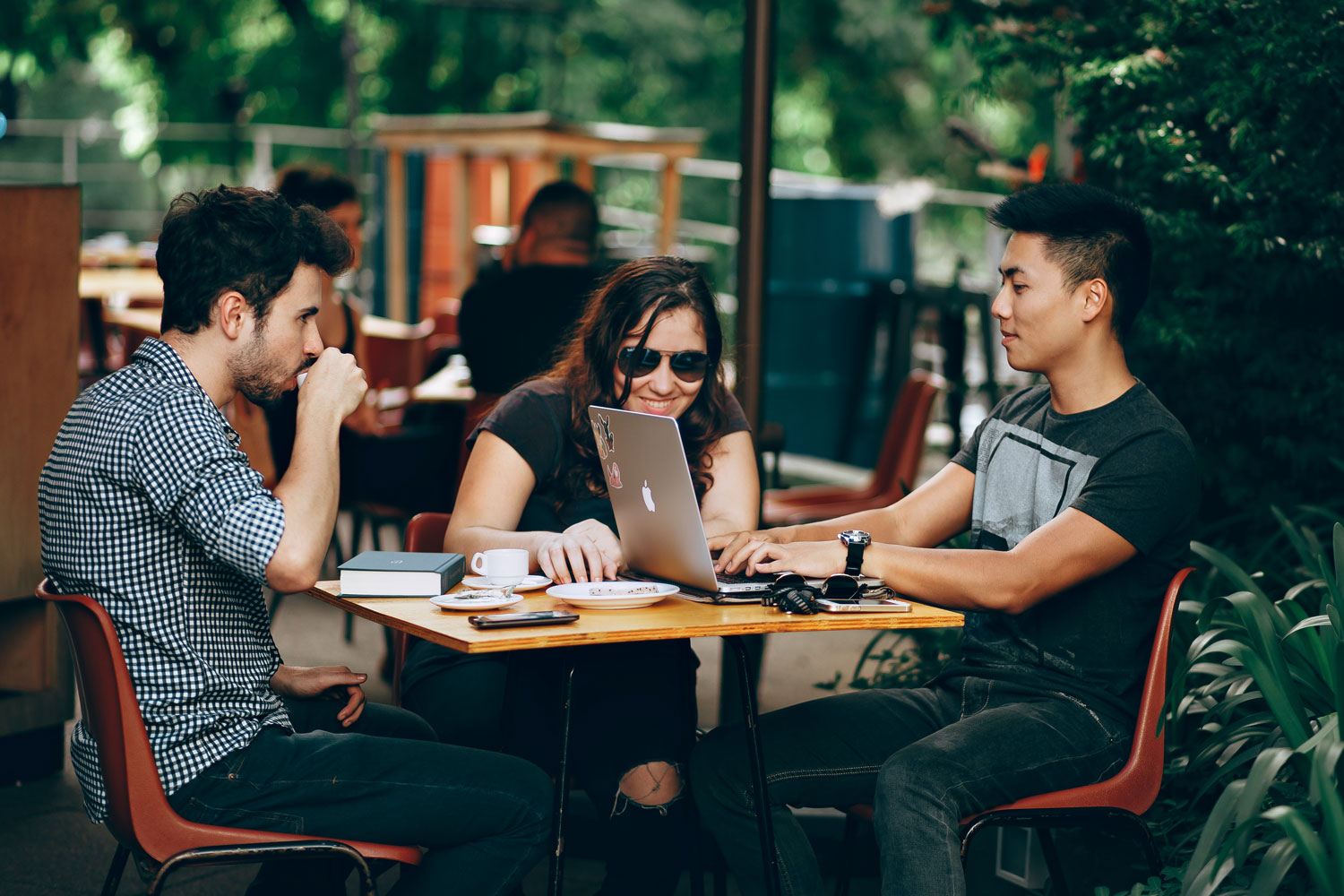 Three people in coffee shop with laptop Three people in coffee shop with laptop