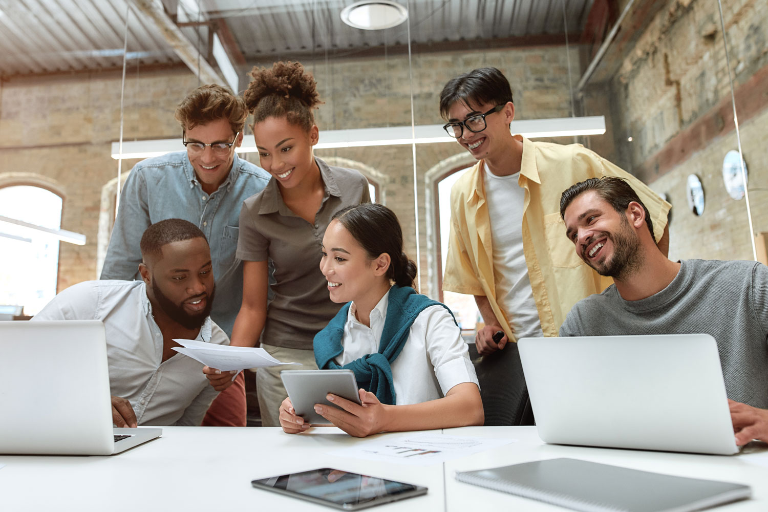 group of young professionals overlooking laptops